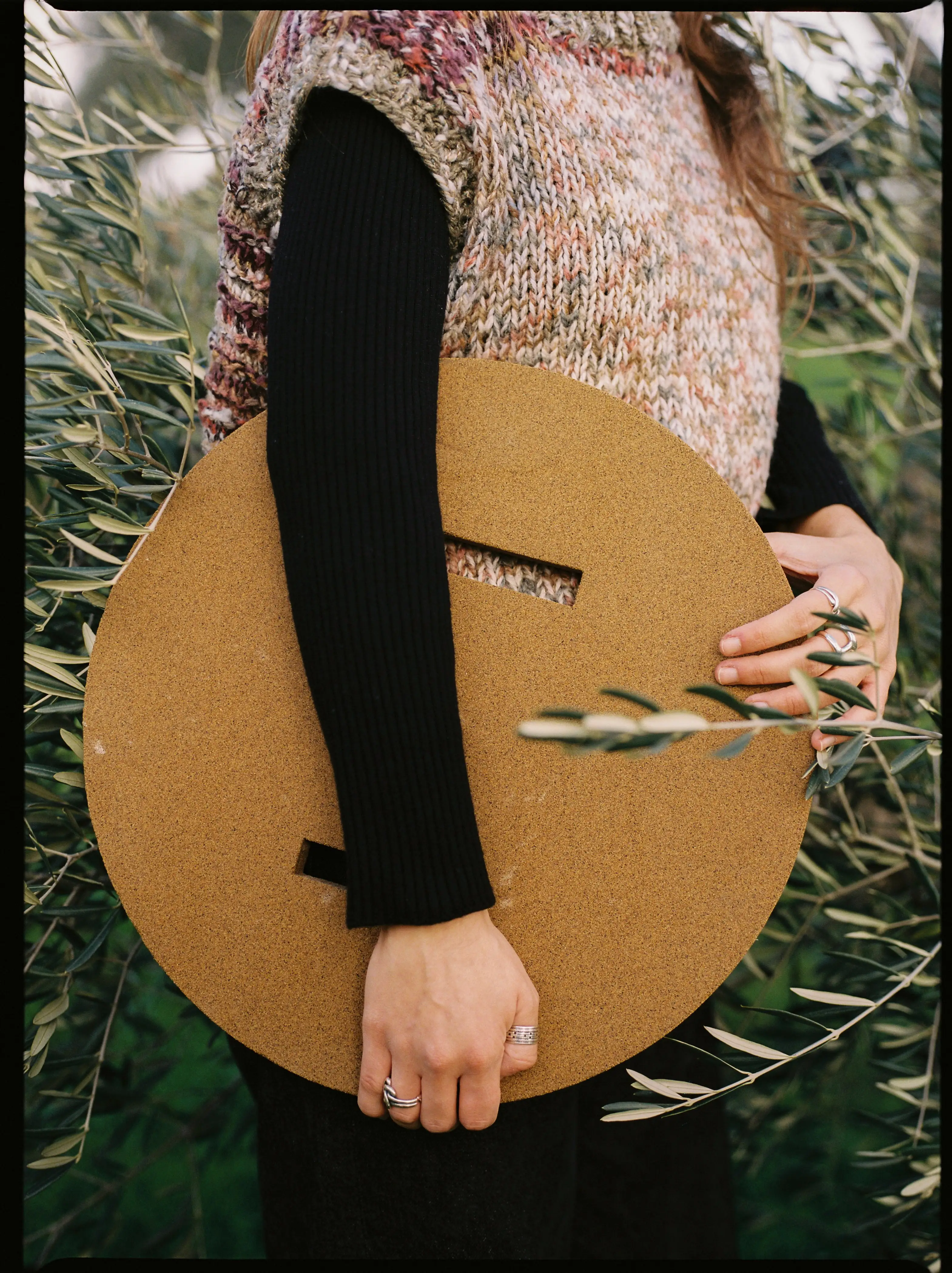 SD=F holding the olive pit composite table top, presenting a circular material design in Portugal