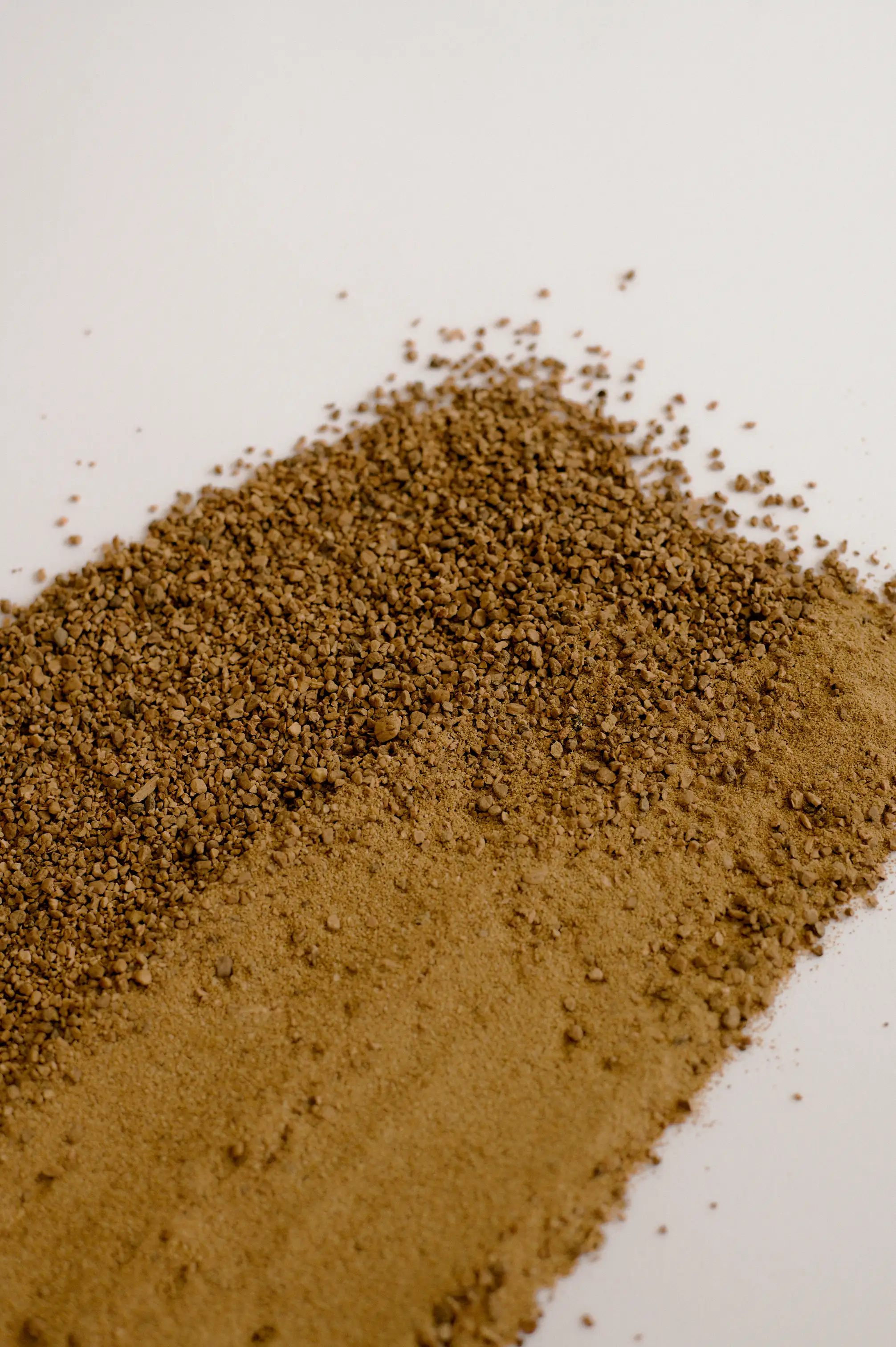 Ground olive pit granules in varying particle sizes, bound to form durable and recyclable composite for This is Not Cork